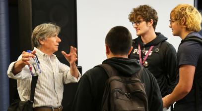 Frank Dungan talks to three students.