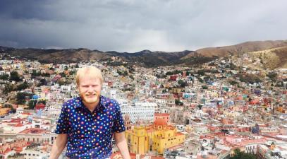 Max Hoverstein sits on ledge in front of colorful houses