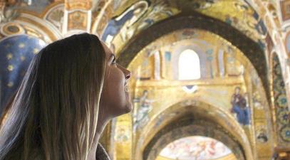 Student looks up at painted cathedral ceiling in Europe.