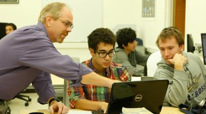 Professor and student study on a laptop