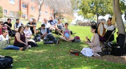 students and musicians sitting on the lawn