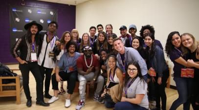 Students pose in a group photo with hip-hop artist, T-Pain