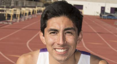 Ruben Solorza stands on the track in his track & field uniform