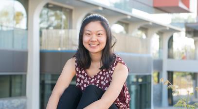 Katrina Wong sits on ledge in front of the science building