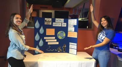 Students point to an information posted for World Water Day