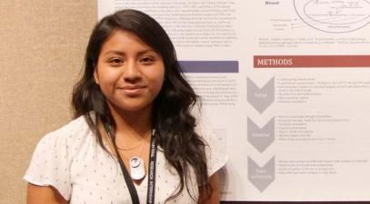 Biochemistry major Jaqueline Yutan stands in front of a scientific poster.