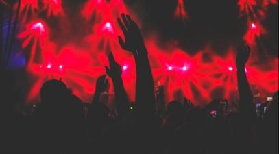 A crowd with hands up in the air at a concert.