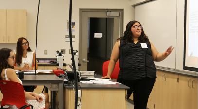 Daniela Vega presents a lecture in a classroom with a small group of people watching.