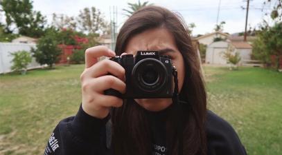 Kelly Santos holds up a camera.