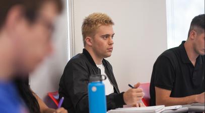 Trevor Tuma listens to a lecture in a classroom.