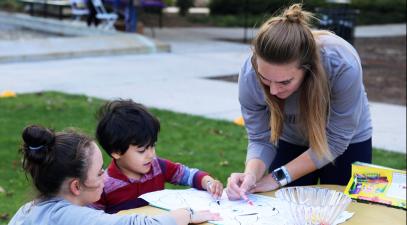 Student playing with two children.