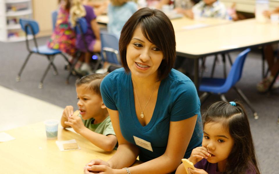 A student sits between two children in a classroom.