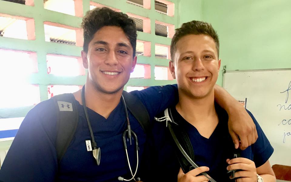 Two students pose for a photo in a clinic.