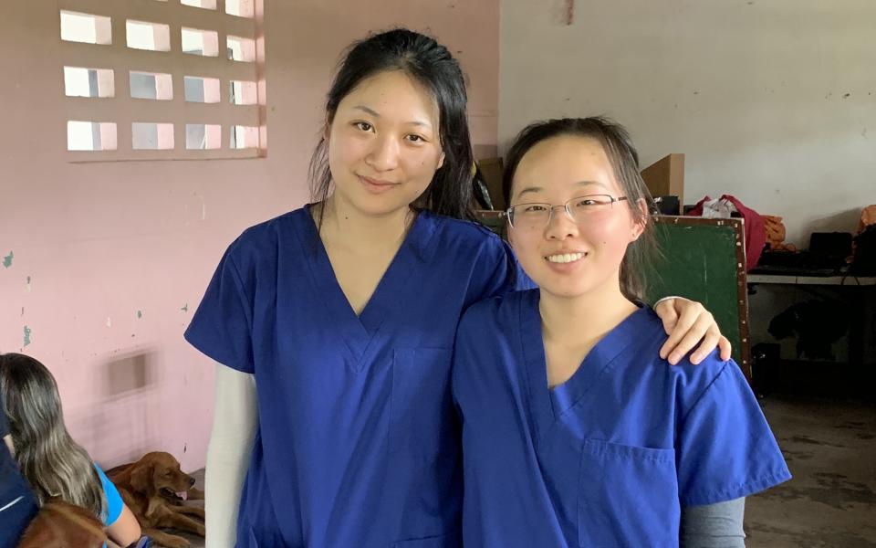 Two students pose for a photo in a clinic.